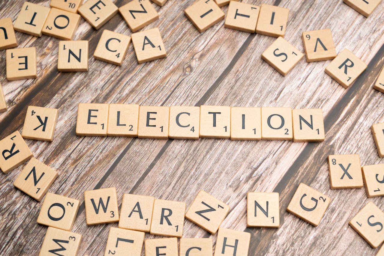 Wooden letter tiles form the word election on a textured wooden surface, symbolizing voting.
